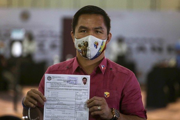 Retired Filipino boxing star and senator Manny Pacquiao shows his certificate of candidacy for next year&#039;s presidential elections shortly after filing before the Commission on Elections at the So ...