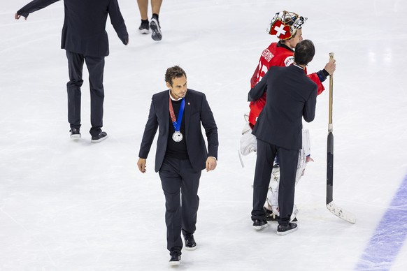 Patrick Fischer, head coach of Switzerland national ice hockey team and Switzerland&#039;s goaltender Leonardo Genoni react after the victory of the team USA during the gold medal game between Switzer ...
