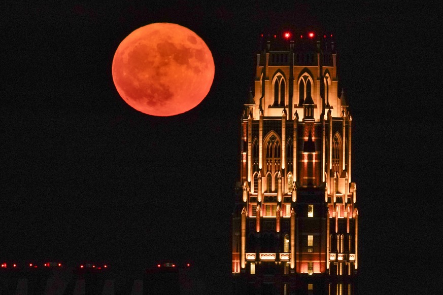 A supermoon rises over the West End Tower at Vanderbilt University, Tuesday, Aug. 1, 2023 in Nashville, Tenn. The Sturgeon moon is the second of four supermoons to appear in 2023. (AP Photo/George Wal ...