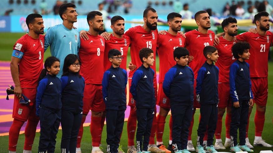 epaselect epa10317852 Players of Iran stand during their national anthem prior to the FIFA World Cup 2022 group B soccer match between England and Iran at Khalifa International Stadium in Doha, Qatar, ...