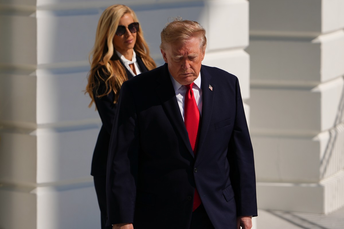 White House press secretary Katie Zacharia watches as President Donald Trump walks to speak with reporters before boarding Marine One on the South Lawn of the White House, Tuesday, Oct. 13, 2026, in W ...