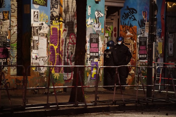 epa08730006 Police officers stand in front of a nearby building a day prior to the planned eviction of the left-wing scene living project Liebig34 (Liebig street 34) in Berlin, Germany, 08 October 202 ...