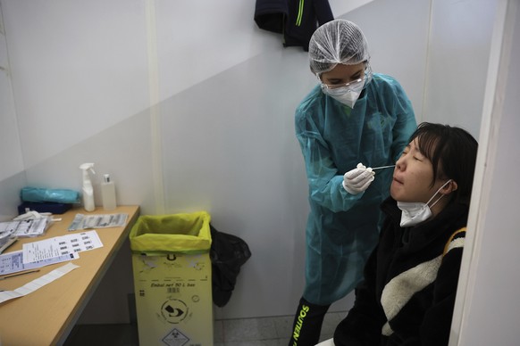 A passenger arriving from China is tested for COVID-19 at the Roissy Charles de Gaulle airport, north of Paris, Sunday, Jan. 1, 2023. France says it will require negative COVID-19 tests of all passeng ...