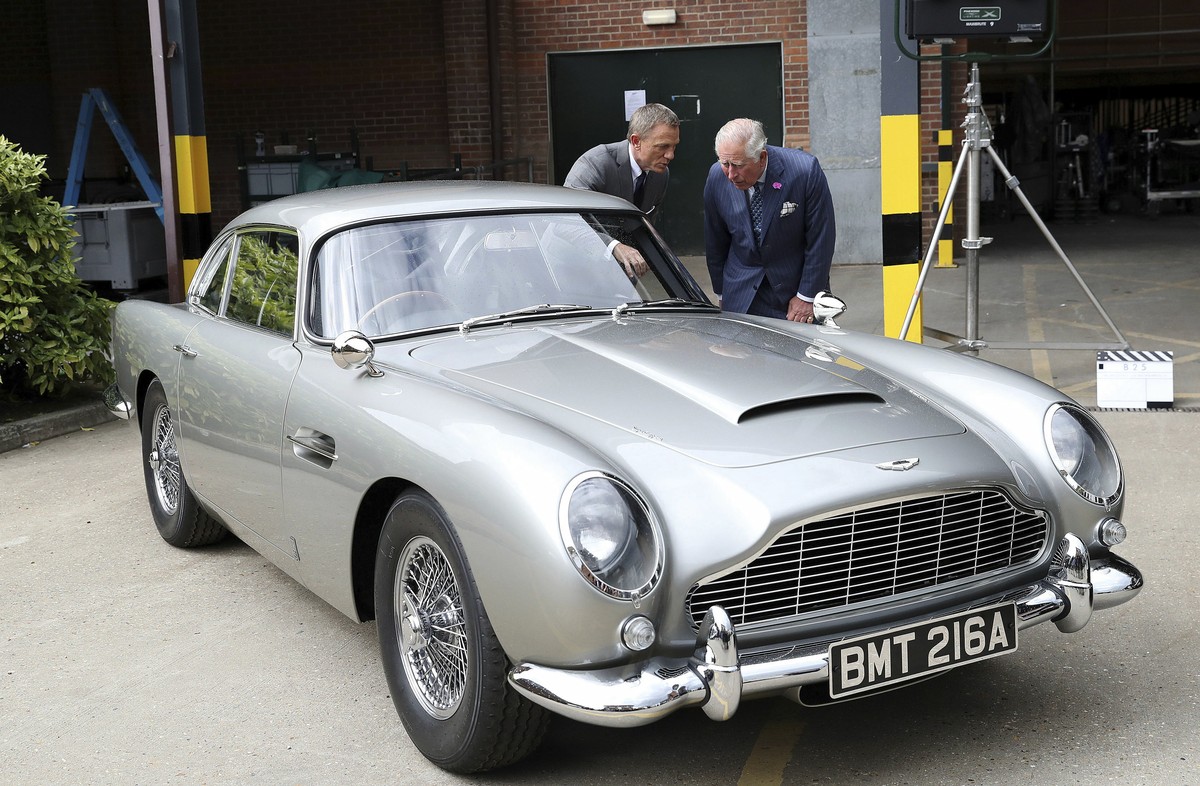 Britain's Prince Charles talks with actor Daniel Craig, left, as they view the Aston Martin DB5 Bond car during a visit to the set of the 25th James Bond film at Pinewood Studios in Iver Heath, s ...