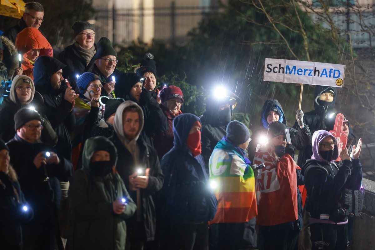11.02.2025, Thüringen, Suhl: Demonstranten stehen unter dem Motto «Suhl bleibt hell» zu einer Lichterkette gegenüber dem Congress Centrum Suhl zusammen. Sie demonstrieren gegen eine Wahlkampfveranstal ...