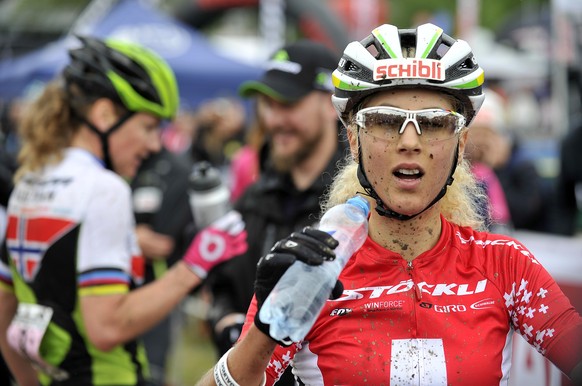 Swiss Jolanda Neff, right, drinks after she won the womenÅ½s mountain biking World Cup race in Nove Mesto na Morave, Czech Republic, Sunday, May 24, 2015. Gunn-Rita Dahle-Flesjaa from Norway, left rea ...