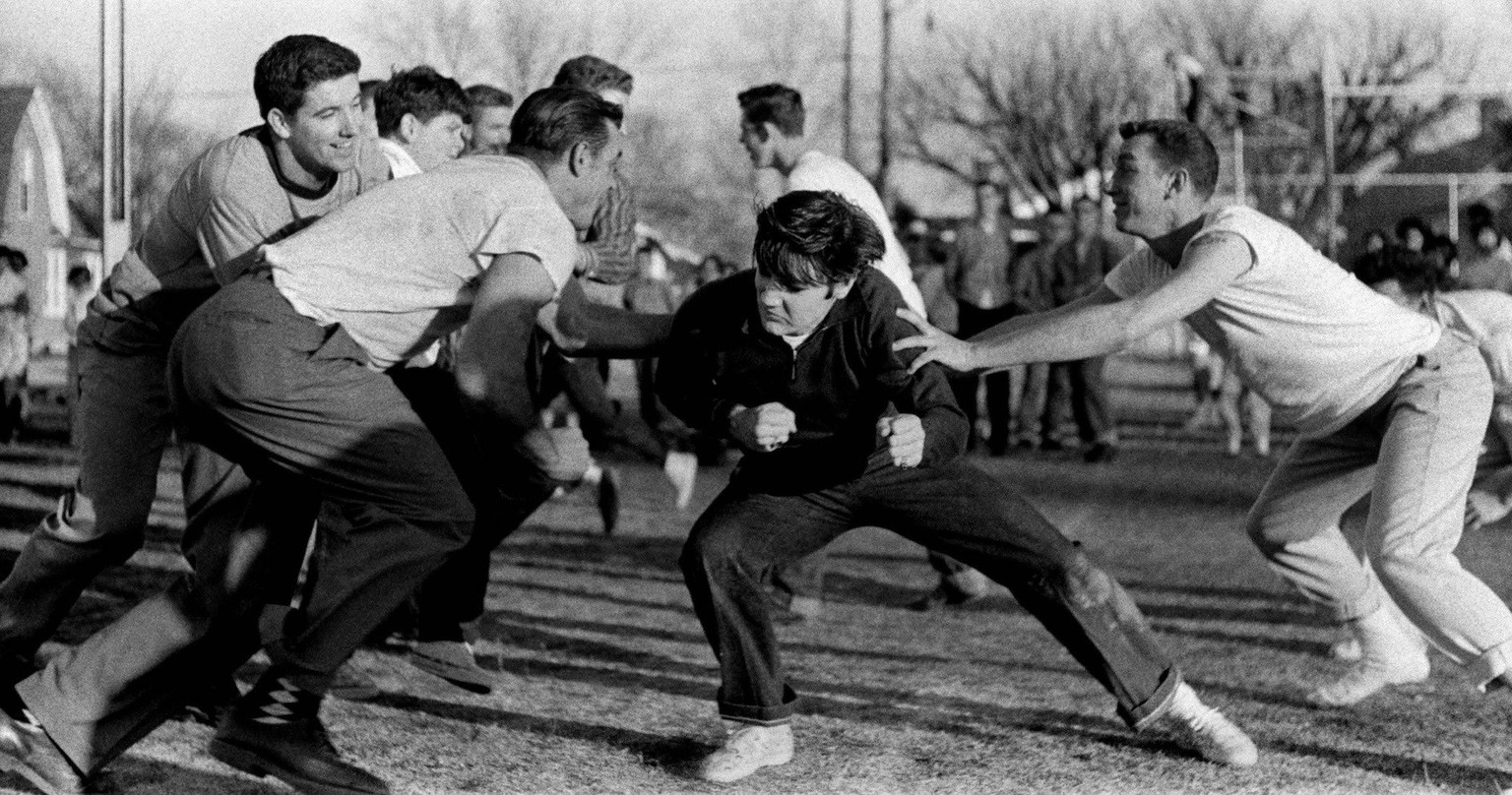 Entertainment: Elvis Presley File Photos December 27, 1956 Memphis, TN, USA Elvis Presley playing touch football at the Dave Wells Community Center December 27, 1956. Several hundred people watched th ...