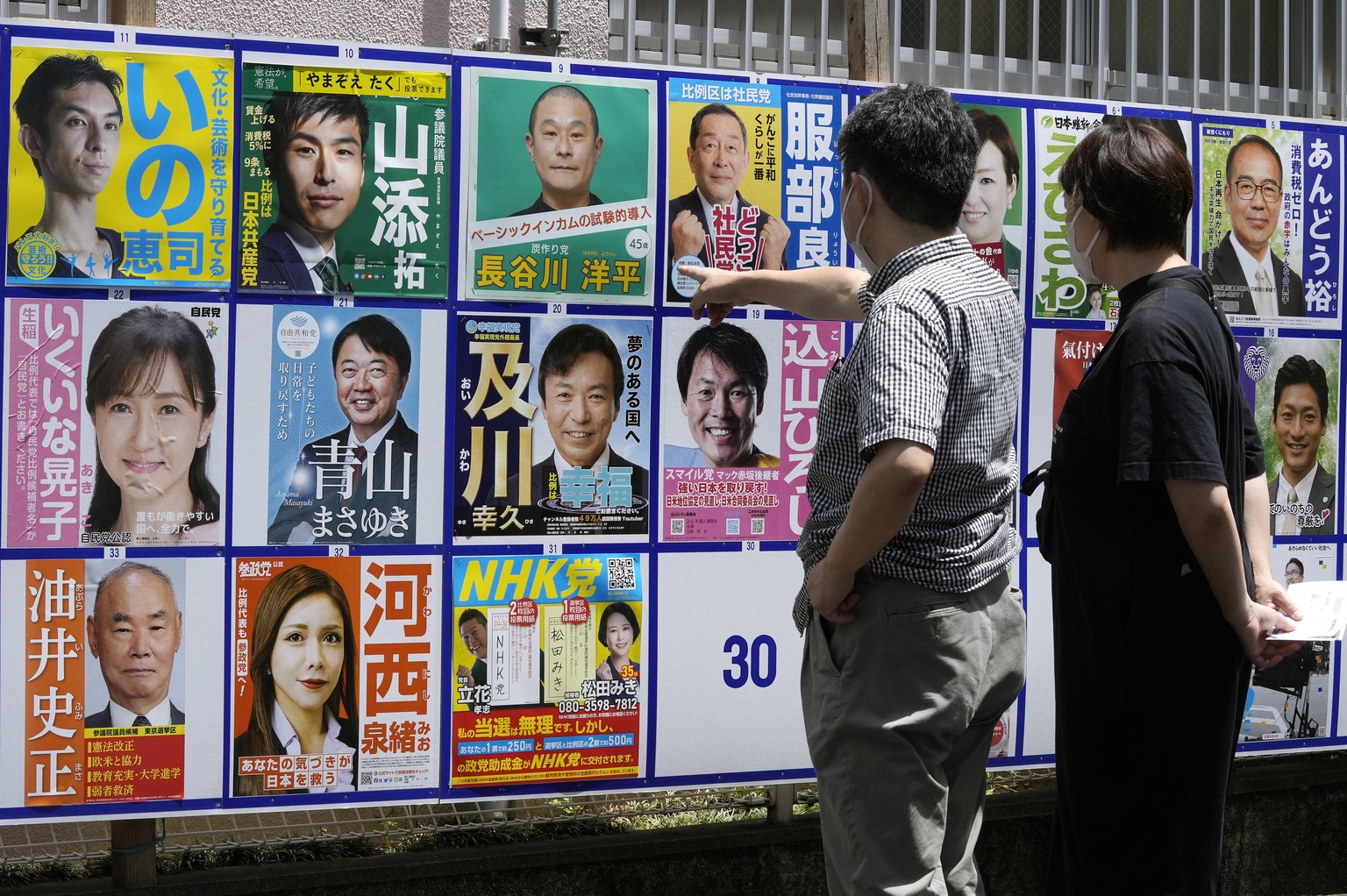 epa10063066 Voters look on posters of candidates for the Upper House election outside a polling station in Tokyo, Japan, 10 July 2022. EPA/KIMIMASA MAYAMA