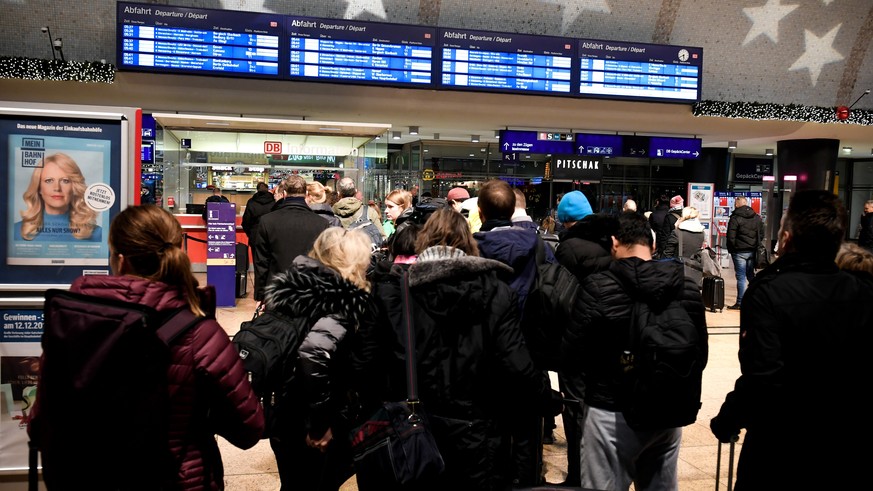 epa07220848 Passengers look at delay information on a display board during a warning strike in railway operations in Germany at Cologne Central Railway Station in Cologne, Germany, 10 December 2018. T ...