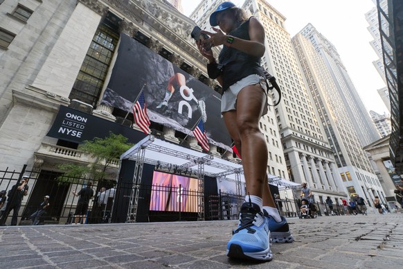 A woman wears On shoes outside the New York Stock Exchange before the company&#039;s IPO, Wednesday, Sept. 15, 2021. (AP Photo/Richard Drew)