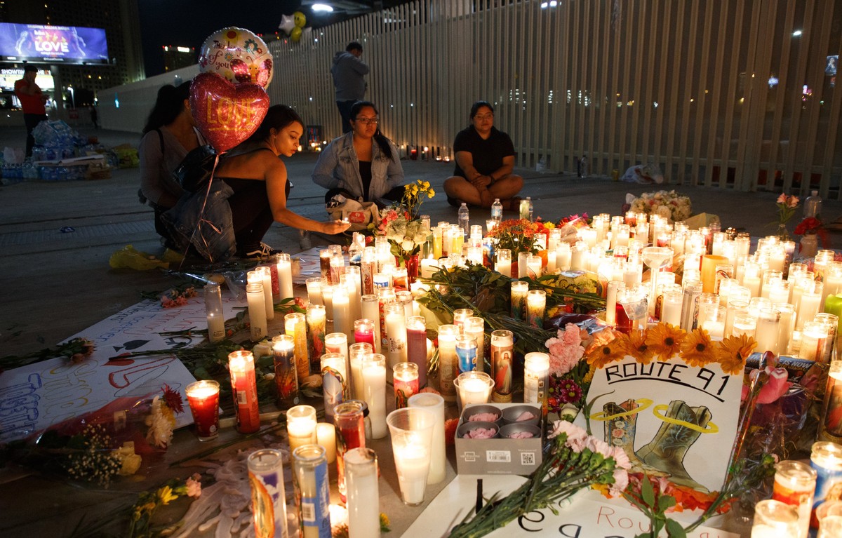 epa06241094 Mourners pay tributes at a makeshift memorial on the Las Vegas Strip for the victims of a mass shooting in Las Vegas, Nevada, USA, 02 October 2017. The mass shooting, which left at least 5 ...