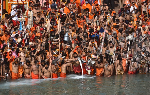 epa09134462 Indian holy men, or Naga Sadhu, along with the other pilgrims take the holy dip in the Ganges River during the Kumbh Mela at Haridwar, Uttarakhand, India, 14 April 2021. Thousands of pilgr ...