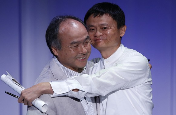 SoftBank Corp. Chief Executive Masayoshi Son (L) hugs Jack Ma, founder and executive chair of Alibaba Group Holding, during the SoftBank World 2014 event in Tokyo July 15, 2014. REUTERS/Toru Hanai (JA ...