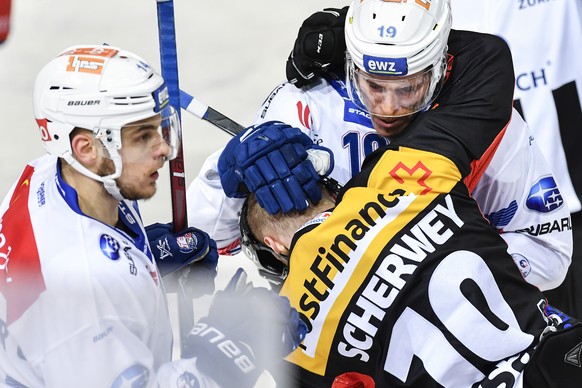 Berns Tristan Scherwey, Mitte, pruegelt sich mit Zuerichs Chris Baltisberger, links, und Reto Schaeppi im fuenften Eishockey Playoff-Halbfinalspiel der National League zwischen dem SC Bern und den ZSC ...