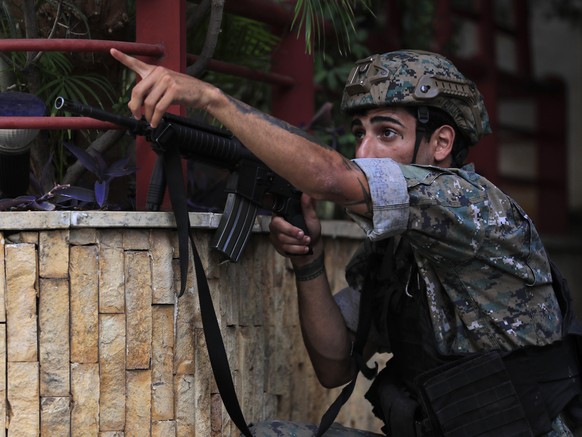 A Lebanese special forces soldiers take his position, as he points to his comrades to a position of a shiite group sniper who was sniping at the Christian neighborhood of Ain el-Remaneh, in Beirut, Le ...