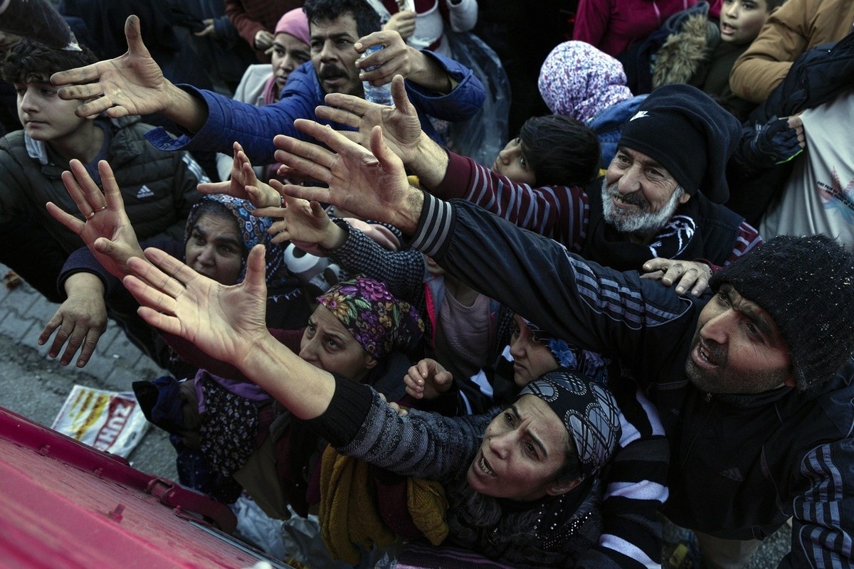 Volunteers distribute aid to people in Antakya, southern Turkey, Wednesday, Feb. 8, 2023. Thinly stretched rescue teams worked through the night into Wednesday, pulling more bodies from the rubble of  ...
