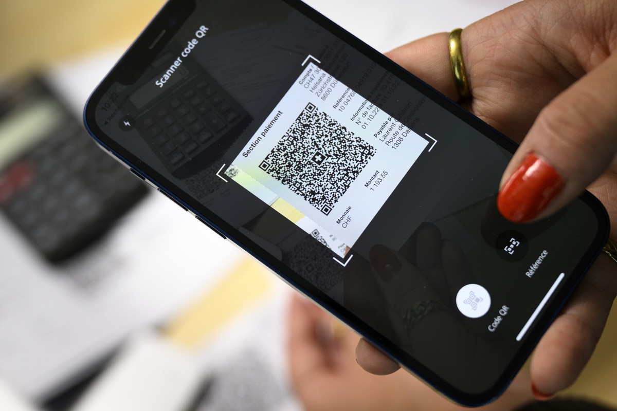 Une personne scanne a l'aide de son smartphone un QR code d'un bulletin de versement, d'une QR-facture, en faisant ses paiements ce mardi 27 septembre 2022 a Lausanne. La QR-facture mod ...