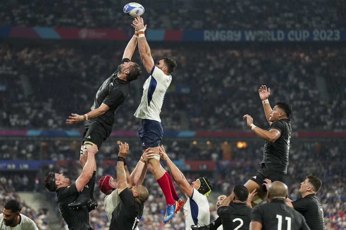 New Zealand's Samuel Whitelock, top left, and France's Charles Ollivon, top right, lunge for the ball during the Rugby World Cup Pool A match between France and New Zealand at the Stade de F ...