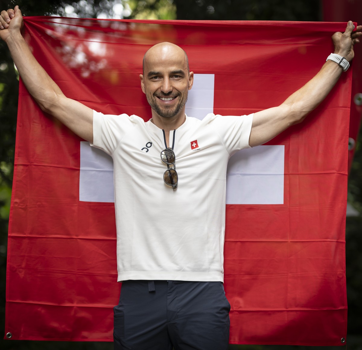Swiss mountainbiker athlete Nino Schurter with the Swiss flag poses at the Maison Suisse during a press conference, prior to the 2024 Paris Summer Olympics in Paris, France, Thursday, July 25, 2024. N ...