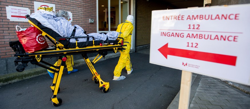 epa08319599 A patient potentially infected with Covid-19 on a stretcher is taken by medical staff wearing protective suits at CHU Saint-Pierre hospital in Brussels, Belgium, 24 March 2020. In order to ...