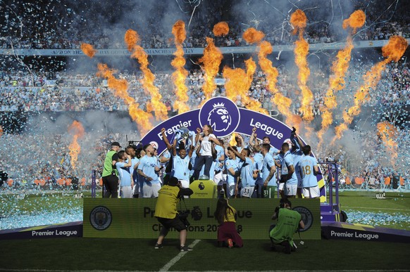 FILE - In this Sunday, May 6, 2018 file photo, Manchester City players lift the English Premier League trophy after the soccer match between Manchester City and Huddersfield Town at Etihad stadium in  ...