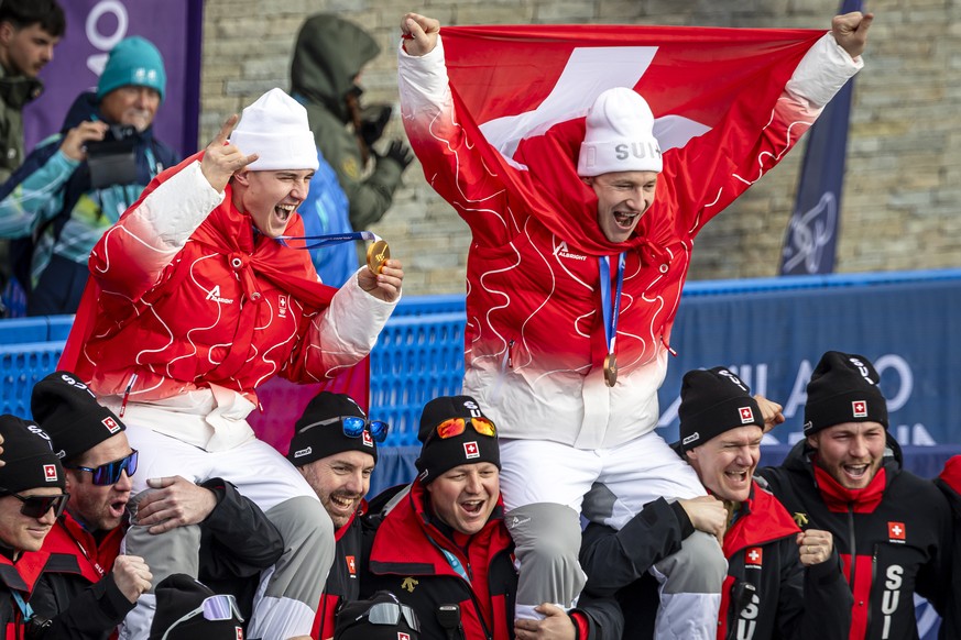 KEYPIX - Gold medalist Franjo von Allmen of Switzerland, left, and bronce medalist Marco Odermatt of Switzerland, pose with team after the men's alpine skiing Super-G race at the 2026 Olympic Win ...