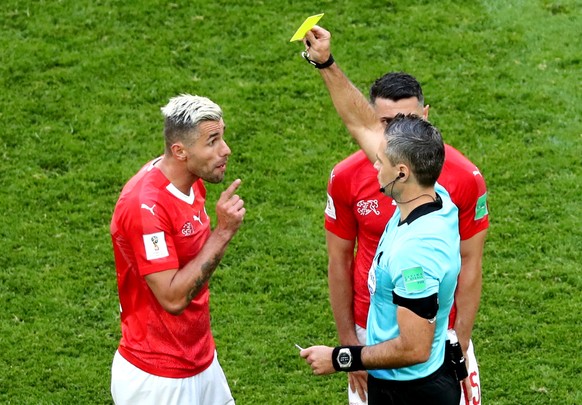 epa06861197 Valon Behrami of Switzerland (L) is booked by Slovenian referee Damir Skomina (R) during the FIFA World Cup 2018 round of 16 soccer match between Sweden and Switzerland in St.Petersburg, R ...