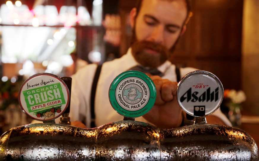 A bartender pours pints of Australian-made Coopers Brewery pale ale beer at a pub in Sydney, Australia, March 15, 2017. REUTERS/Jason Reed