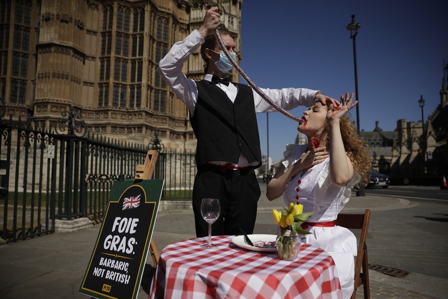 PETA (People for the Ethical Treatment of Animals) activists pose for photographs in a protest stunt calling on the British government to state when and how they will enact a ban they previously annou ...