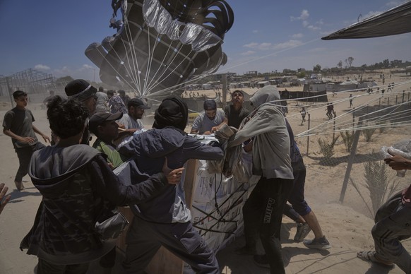 FILE - Palestinians rush to collect humanitarian aid airdropped by parachutes into Deir al-Balah, central Gaza Strip, Tuesday, Aug. 5, 2025. (AP Photo/Abdel Kareem Hana, File)
Mideast Wars Gaza Hunger