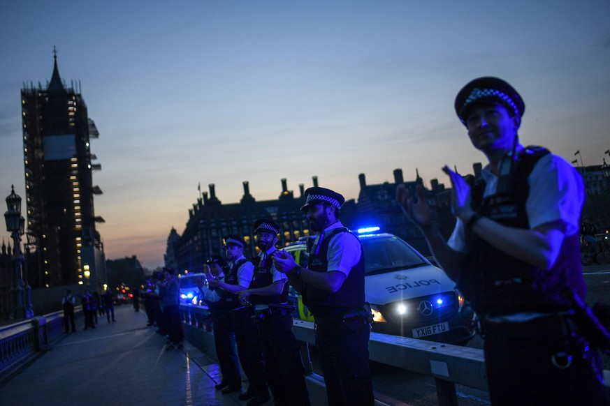 LONDON, ENGLAND - APRIL 09: Police officers are seen applauding NHS staff and key workers on Westminster Bridge on April 09, 2020 in London, England. Following the success of the "Clap for Our Ca ...