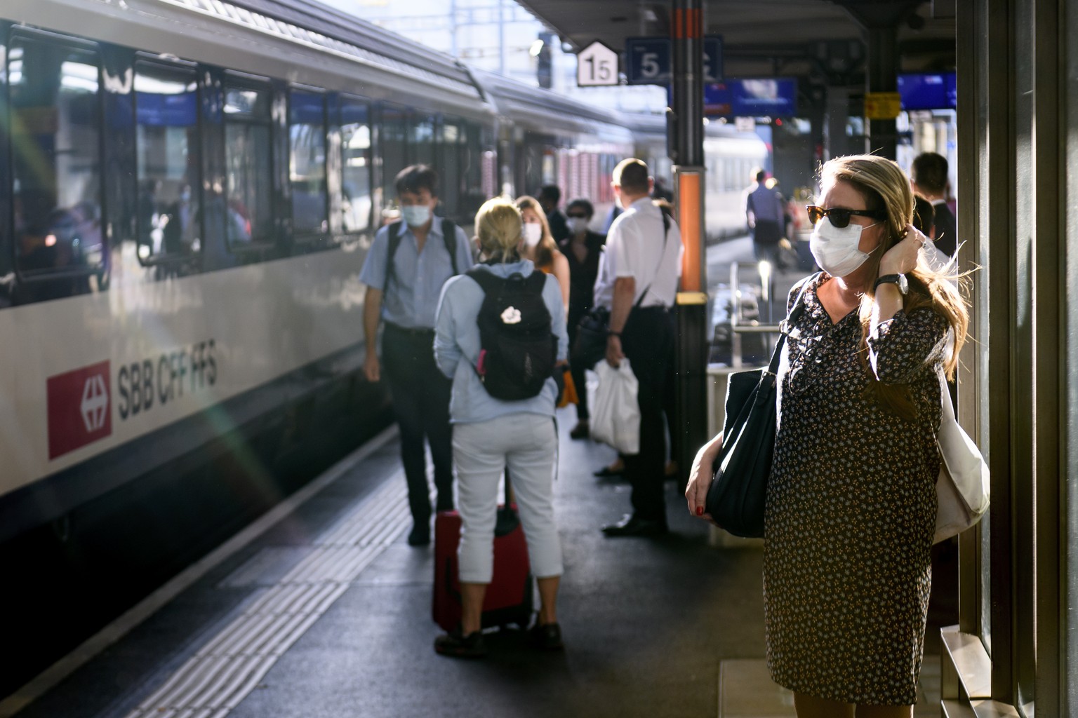 People wearing protective mask get wait a SBB CFF train during the coronavirus disease (COVID-19) outbreak, at the train station CFF in Lausanne, Switzerland, Monday, July 6, 2020. In Switzerland, fro ...