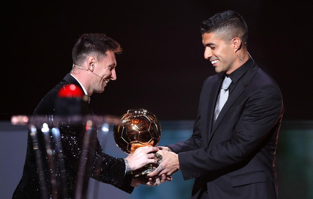 epa09611688 PSG player Lionel Messi (L) receives the Men's Ballon d'Or from his former Barcelona teammate Luis Suarez at the 2021 Ballon d'Or ceremony at Theatre du Chatelet in Paris, F ...