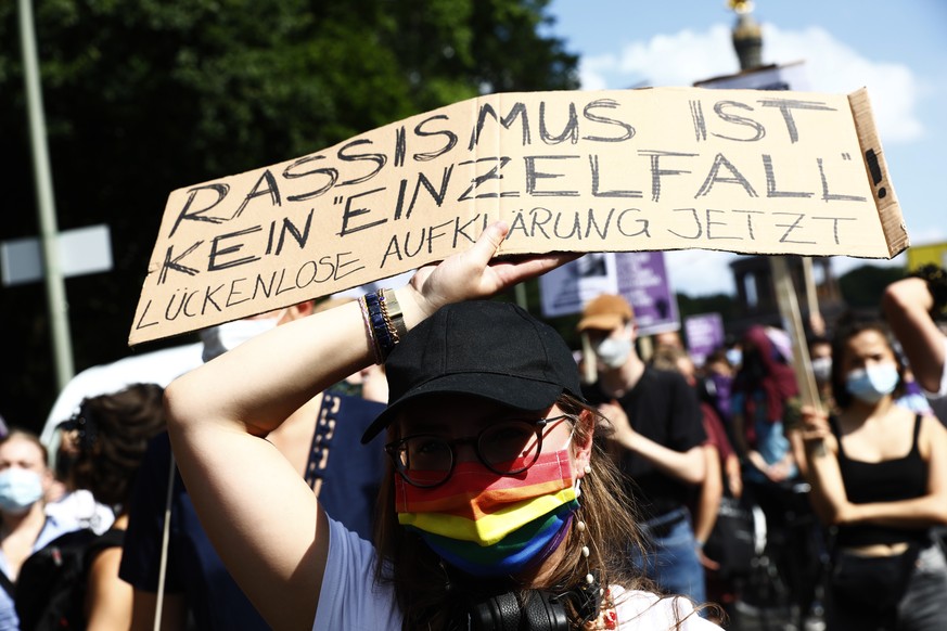 Eine Demonstrantin hält während eines Protests in Berlin gegen Rassismus und Polizeigewalt ein Schild in die Höhe, 18. Juli 2020. 