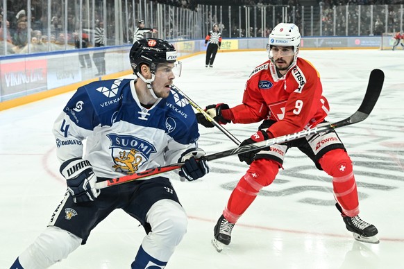 epa09928505 Swizterland ?s Damien Riat (R) and Finland ?s Mikko Lehtonen (L) in action during the EHT ice hockey match between Finland and Switzerland in Tampere, Finland, 05 May 2022. EPA/KIMMO BRAND ...