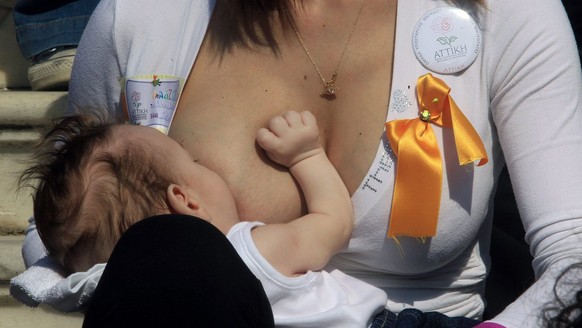 epa03934699 A woman breastfeeds her baby during a public breastfeeding for the celebration of Breastfeeding Week in Athens, Greece, 03 November 2013. Mothers breastfed their babies in the 4th Panhelle ...