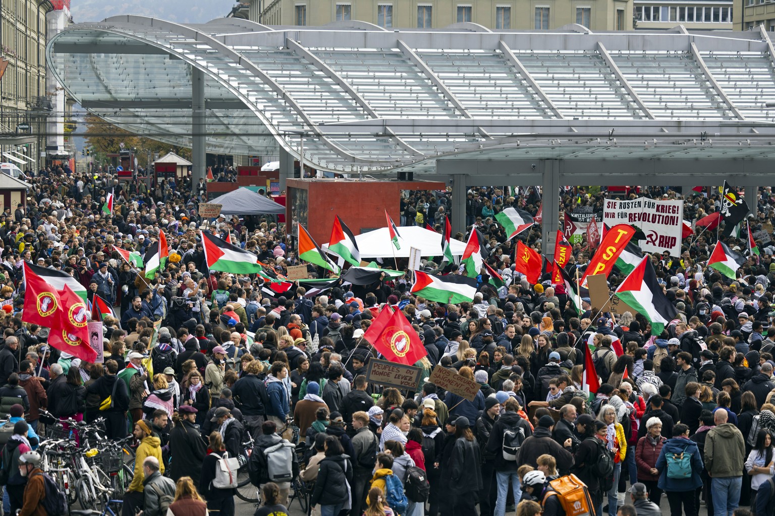 epa12446753 People hold banners and wave Palestinian flags during an unauthorized rally in solidarity with the Palestinian people in Bern, Switzerland, 11 October 2025. EPA/PETER KLAUNZER