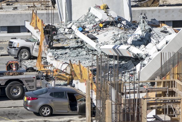 epa06606847 View of the collapsed pedestrian bridge on the Florida International University in Miami, Florida, USA on 15 March 2018. A recently installed pedestrian bridge at Florida International Uni ...