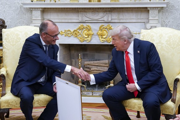 epa12158328 German Chancellor Friedrich Merz (L) presents US President Donald J Trump with what he said is the birth certificate of Trump&#039;s grandfather, &#039;Born in 1869,&#039; as they meet at  ...
