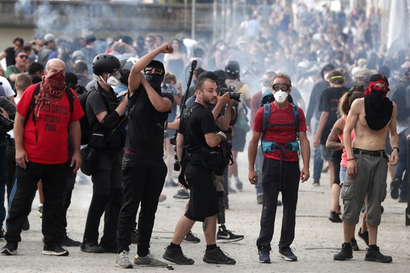 epa07791255 A protestor throws projectiles to French anti-riot police clashes during an anti-G7 demonstration in Bayonne, near Biarritz, France, 24 August 2019, on the opening day of the G7 summit. Th ...