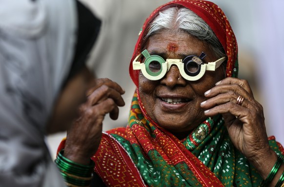 epa06371419 A supporter of Dr Bhim Rao Ambedkar gets a free eye examination during the celebration for Ambedkar 61st death anniversary in Mumbai, India, 06 December 2017. Thousands of people from Maha ...