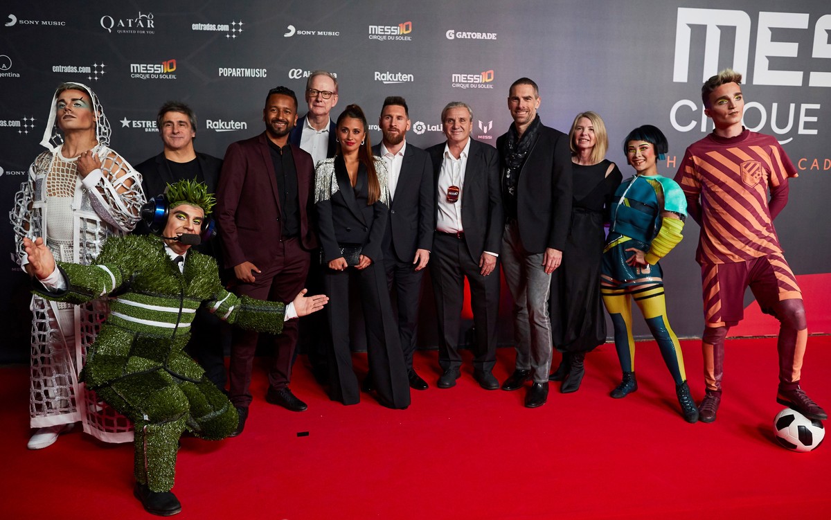 epa07911255 FC Barcelona's forward Lionel Messi (6-R) from Argentina and his wife Antonela Rocuzzo (7-R) pose for the media with Cirque du Soleil members upon arrival to the premiere of the Cirqu ...
