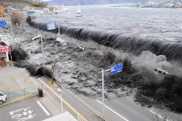 Tsunamiwelle trifft die Küstenstadt Miyako im März 2011 in Japan.
