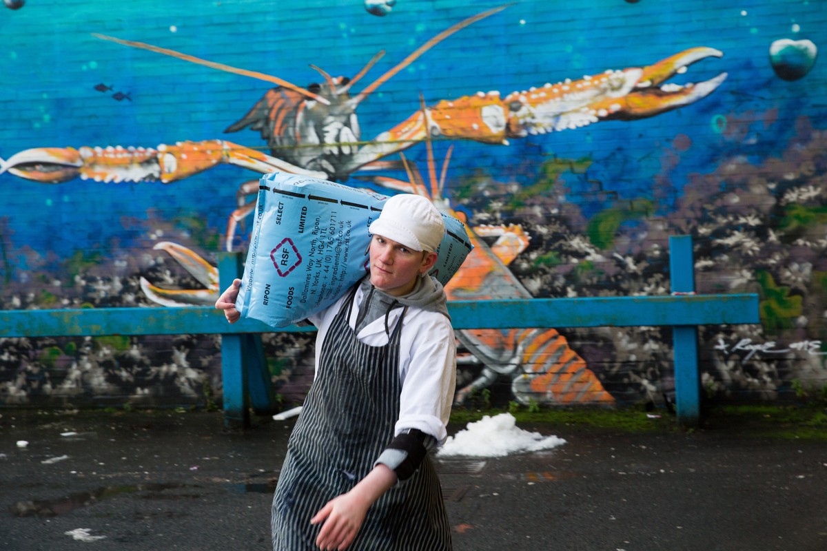epaselect epa08872661 A staff carries a bag at the Glasgow Fish Market at Blochairn, Glasgow, Scotland, Britain, 09 December 2020. Fishing rights is one of the key issues still to be settled in a post ...