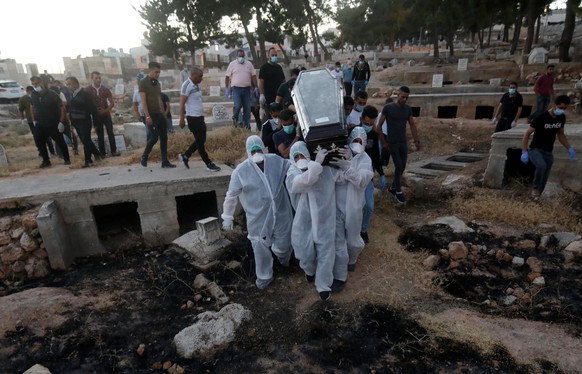 epa08546097 Relatives carry a coffin with the body of 54-year-old Palestinian Mohammad Sallem, who has died with Covid-19 during his funeral in the West Bank city of Hebron, 14 July 2020, amid the ong ...