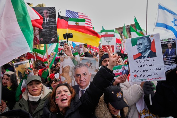 Supports of Iran's exiled Crown Prince Reza Pahlavi attend a demonstration during the Munich Security Conference in Munich, Germany, Saturday, Feb. 14, 2026. The poster right reads: "We cong ...