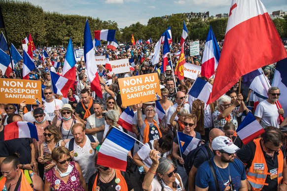 epa09447286 Protesters hold French flags and Anti Pass posters as they gather during a demonstration held by right-wing party &#039;Les Patriotes&#039; against the COVID-19 sanitary pass which grants  ...