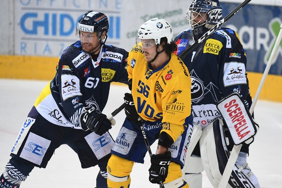 Ambri&#039;s player Franco Collenberg, Davos&#039;s player Dino Wieser and Ambri&#039;s goalkeeper Benjamin Conz, from left, fight for the puck, during the preliminary round game of National League Sw ...