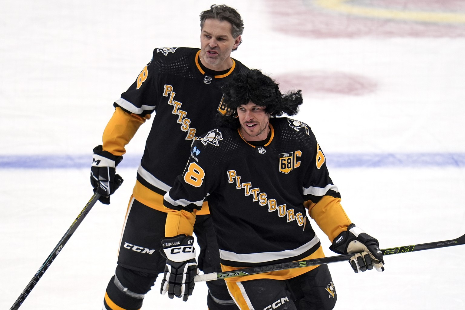 Former Pittsburgh Penguins player Jaromir Jagr, rear, skates in warm ups with Penguins captain Sidney Crosby after having his number retired during a pregame ceremony before an NHL hockey game between ...