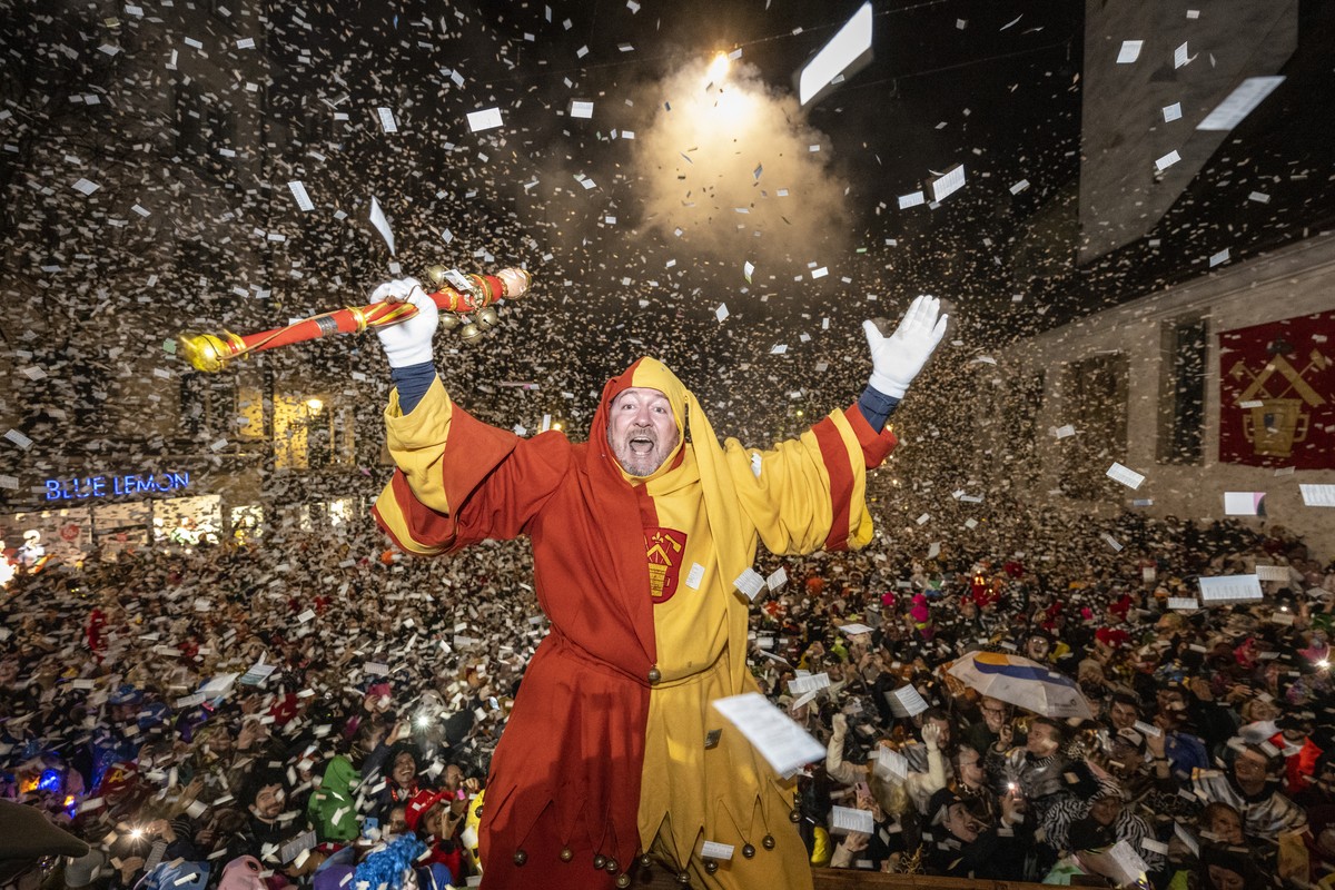 Ein Narr geniesst den 'Foetzeliraege' auf dem Kapellplatz an der Fritschi-Tagwache der Luzerner Fasnacht am Schmutzigen Donnerstag, 8. Februar 2024 in Luzern. Die Luzerner Fasnacht dauert vo ...